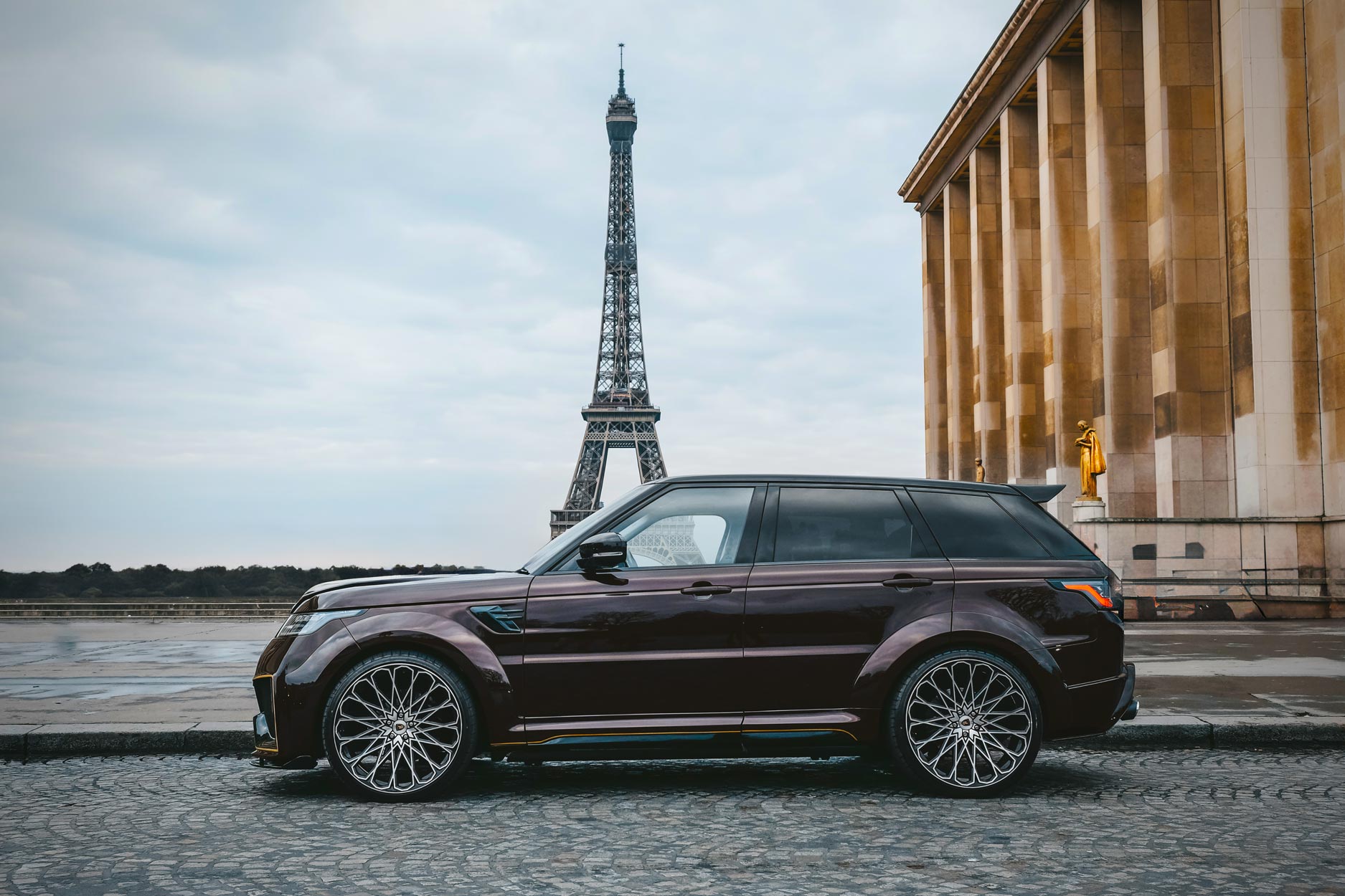 Side view of a Brown Range Rover Sport L494 2018-2022. Shot outside Paris high street. Fitted with Barugzai Majestic 24” alloy wheels, in Gloss Black Polished Face.