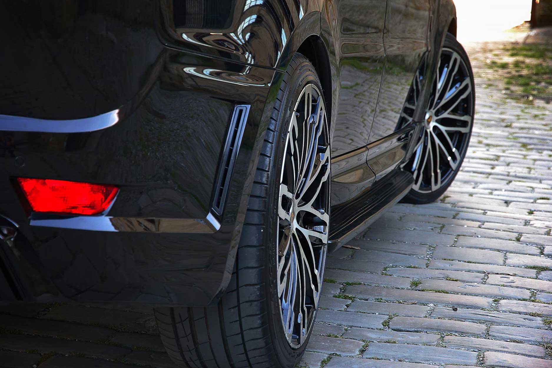 Rear quarter detail view of a Black Range Rover Sport L494 2013-2017. Shot outside an old mill. Fitted with Barugzai Dawn 22” alloy wheels, in Gloss Black Polished Face.