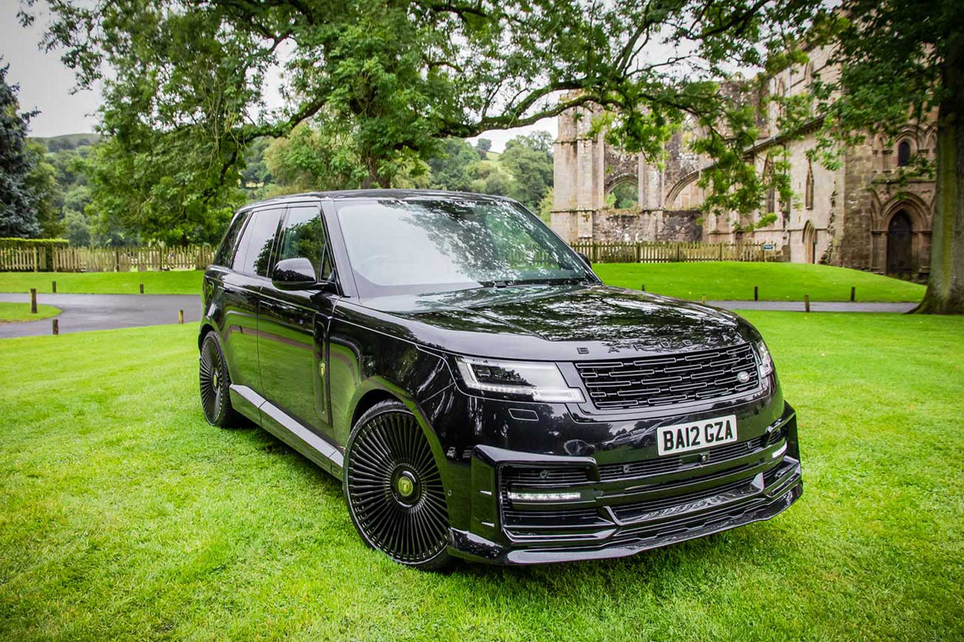 Front quarter view of a Black Range Rover L460 2022+. Shot outside an old Abbey. Fitted with Barugzai Vortex Forged 24” alloy wheels, in Gloss Black Polished Face.